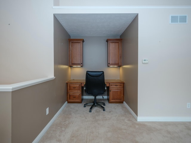 office with baseboards, visible vents, and light colored carpet