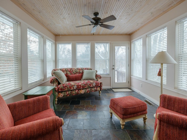 sunroom featuring a ceiling fan, wooden ceiling, and plenty of natural light