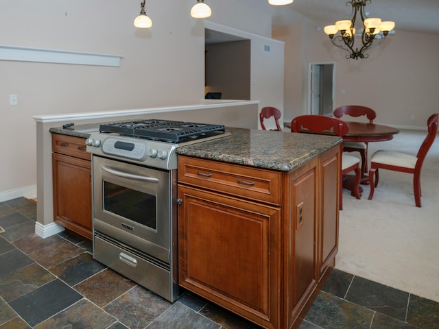 kitchen with stainless steel gas stove, stone tile floors, brown cabinets, hanging light fixtures, and a chandelier