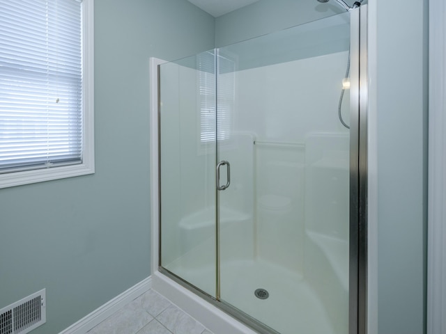 full bath with a stall shower, tile patterned flooring, visible vents, and baseboards