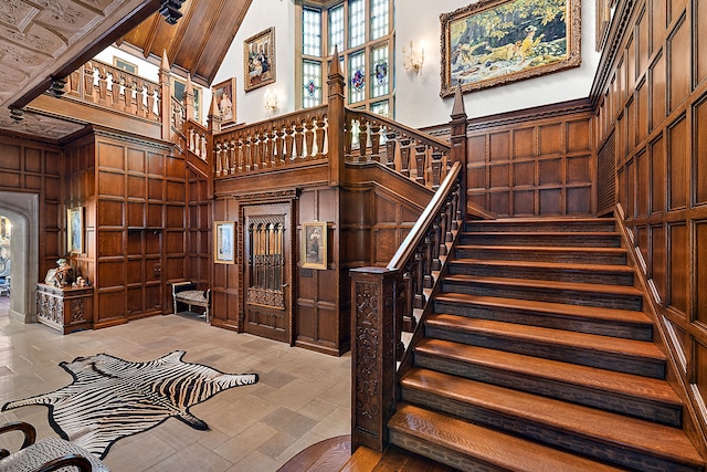 1771 Balmoral Dr, Detroit, MI 48203 - staircase with wooden walls, a high ceiling, and a decorative wall