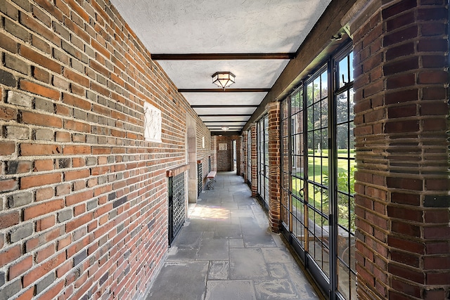 1771 Balmoral Dr, Detroit, MI 48203 - corridor with stone tile flooring, a textured ceiling, and brick wall