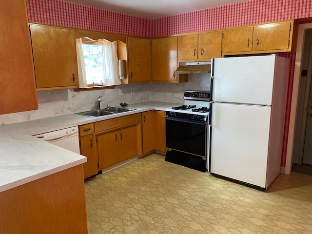 kitchen with under cabinet range hood, white appliances, a sink, light countertops, and light floors