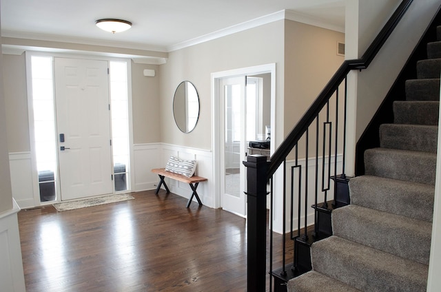 foyer with dark wood-style floors, visible vents, ornamental molding, wainscoting, and stairs