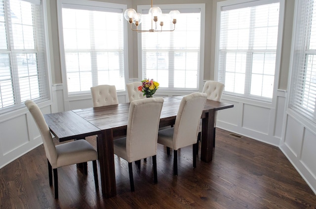 dining space featuring visible vents, a decorative wall, and a wealth of natural light