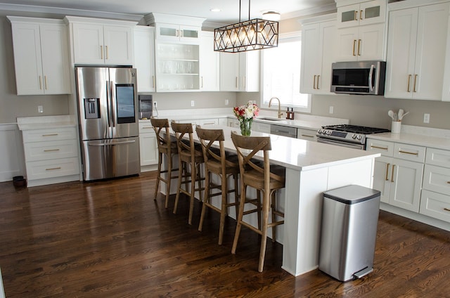 kitchen featuring stainless steel appliances, light countertops, glass insert cabinets, and a center island