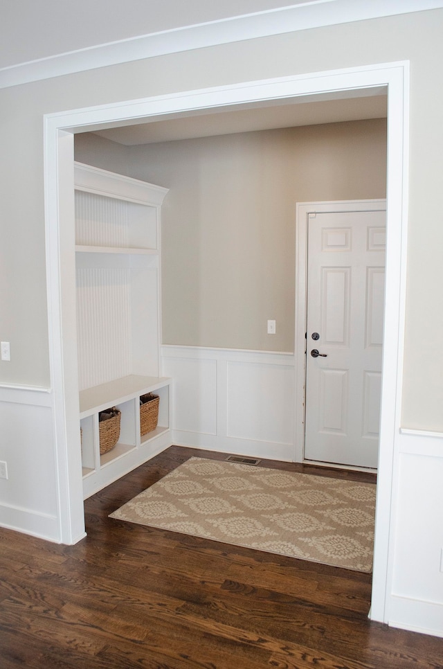 mudroom with dark wood-style flooring and wainscoting