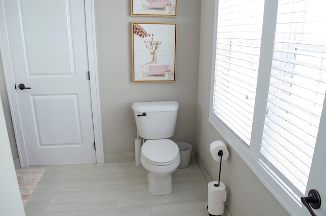 bathroom with toilet and baseboards