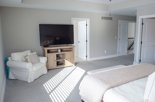 bedroom with baseboards, visible vents, and light colored carpet