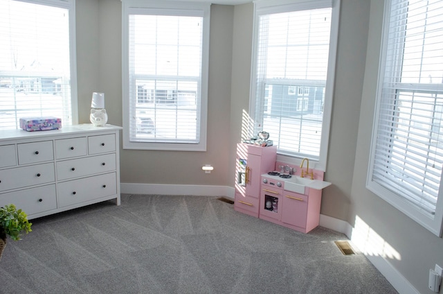 recreation room featuring carpet flooring, visible vents, and baseboards