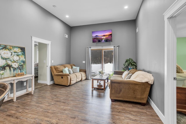 living area with recessed lighting, dark wood-style flooring, and baseboards