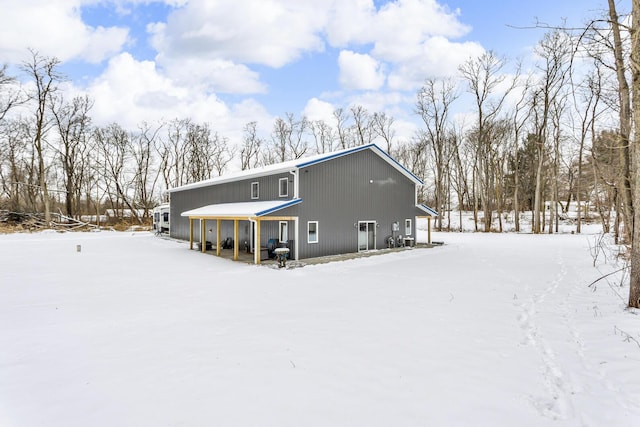 view of snow covered back of property