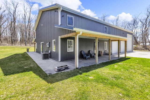 229 S Sutton Rd, Jackson, MI 49203 - back of property featuring a lawn, driveway, cooling unit, a patio, and a garage