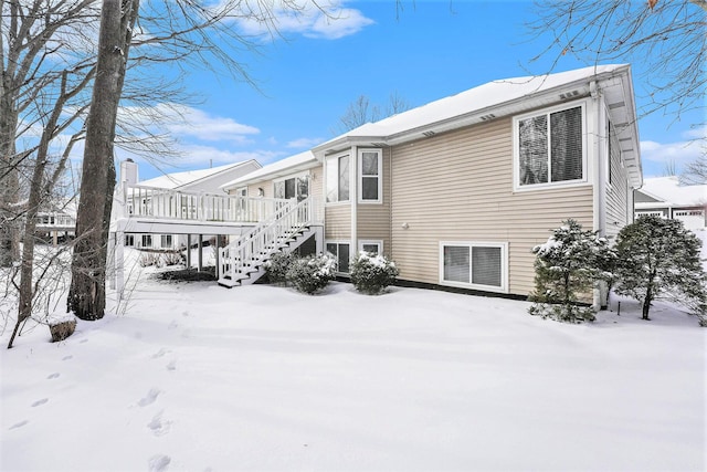 view of snow covered exterior featuring a deck and stairs