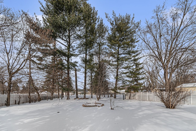 yard covered in snow with a fenced backyard