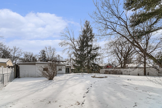 snowy yard featuring fence