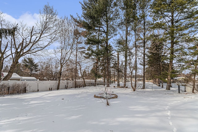 yard covered in snow with a fenced backyard