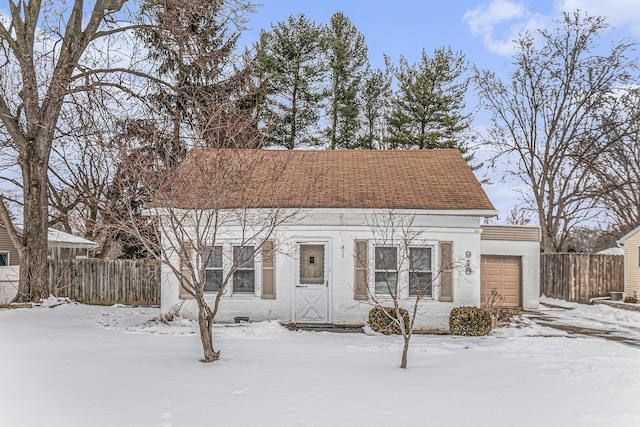 view of front of home featuring a garage, fence, and stucco siding