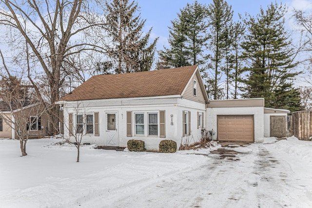 view of front of property with an attached garage, roof with shingles, and stucco siding