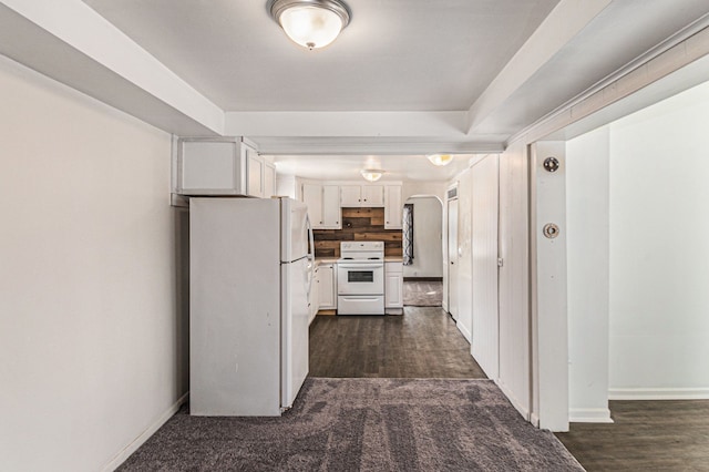 kitchen with white appliances, baseboards, arched walkways, dark wood finished floors, and white cabinetry