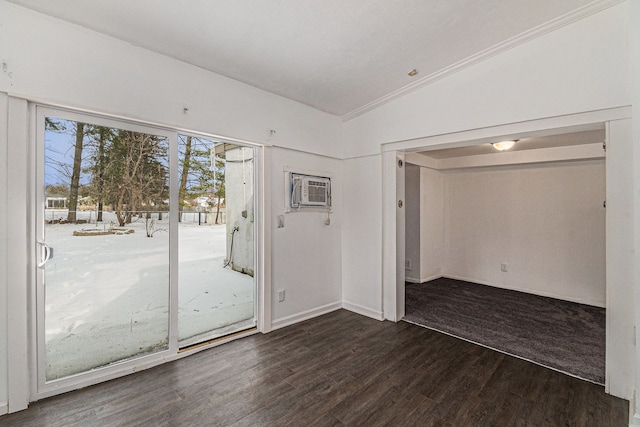 unfurnished room featuring vaulted ceiling, wood finished floors, and an AC wall unit