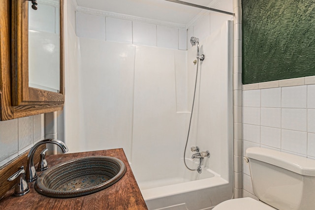 full bath with shower / bath combination, a sink, toilet, and tile walls