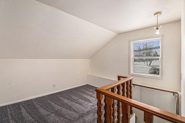 interior space featuring carpet, baseboards, and vaulted ceiling