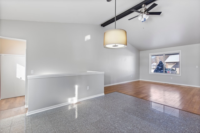 empty room featuring vaulted ceiling with beams, granite finish floor, baseboards, and ceiling fan