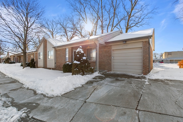 view of front of property featuring a garage, brick siding, and driveway