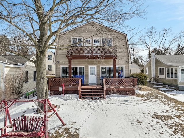 snow covered property with a wooden deck