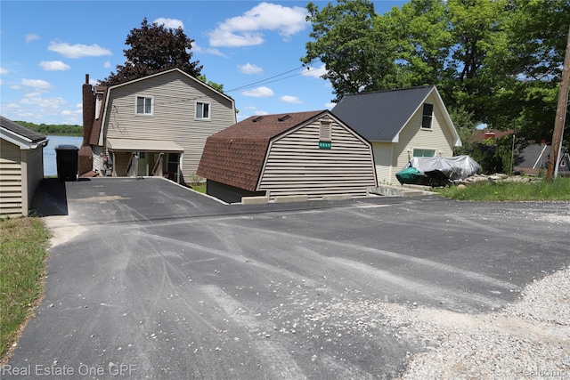 8860 Rushside Dr, Pinckney, MI 48169 - view of front of home featuring a gambrel roof and asphalt driveway