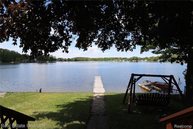 8860 Rushside Dr, Pinckney, MI 48169 - view of green lawn with a water view and a dock