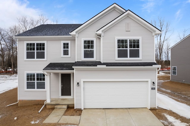 traditional-style house featuring roof with shingles, driveway, and an attached garage