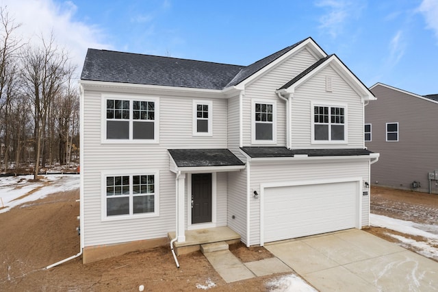 traditional home with concrete driveway, roof with shingles, and an attached garage