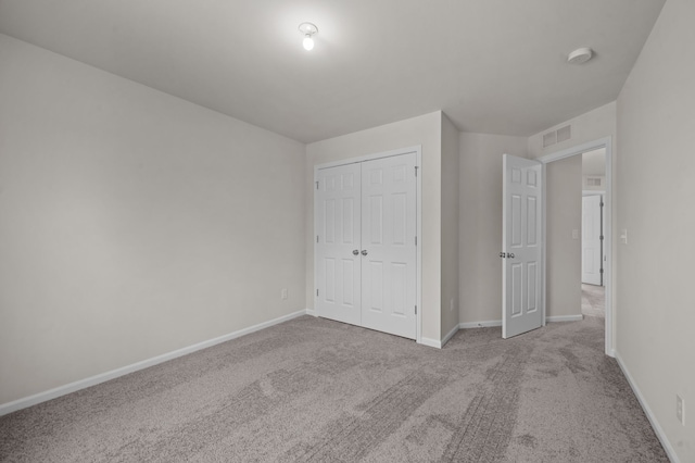 unfurnished bedroom with carpet, a closet, visible vents, and baseboards