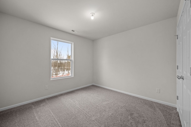 carpeted empty room featuring baseboards and visible vents