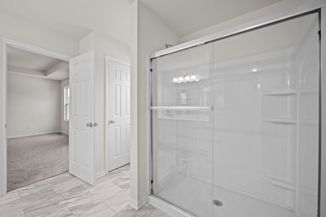 full bath with a shower stall and baseboards