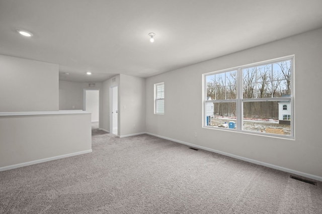 carpeted empty room featuring visible vents, baseboards, and recessed lighting