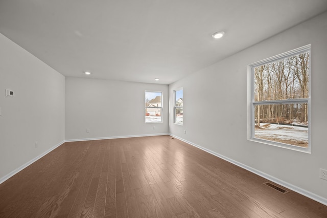 spare room featuring recessed lighting, visible vents, baseboards, and wood finished floors