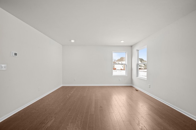 unfurnished room featuring visible vents, baseboards, wood finished floors, and recessed lighting