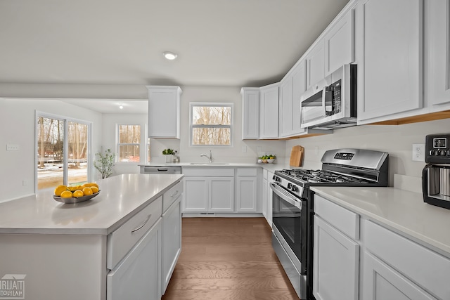 kitchen featuring a sink, white cabinetry, stainless steel appliances, and light countertops