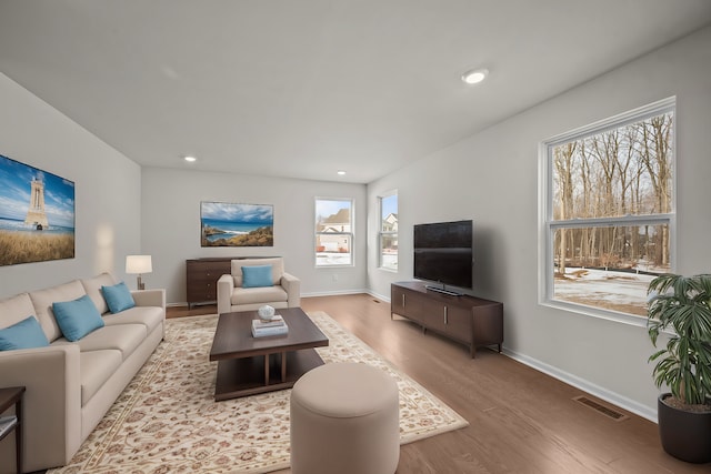 living room featuring baseboards, recessed lighting, visible vents, and light wood-style floors