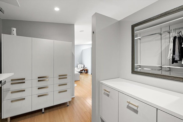 interior space with wood finished floors, vanity, and recessed lighting