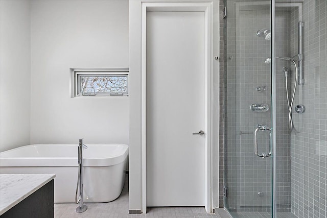 bathroom featuring a freestanding bath, a shower stall, and vanity