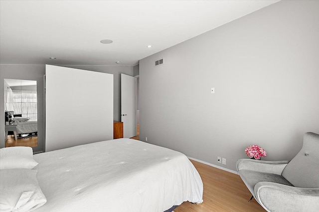 bedroom featuring visible vents, light wood-style flooring, and baseboards