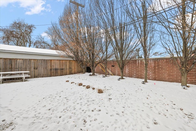 yard layered in snow with fence