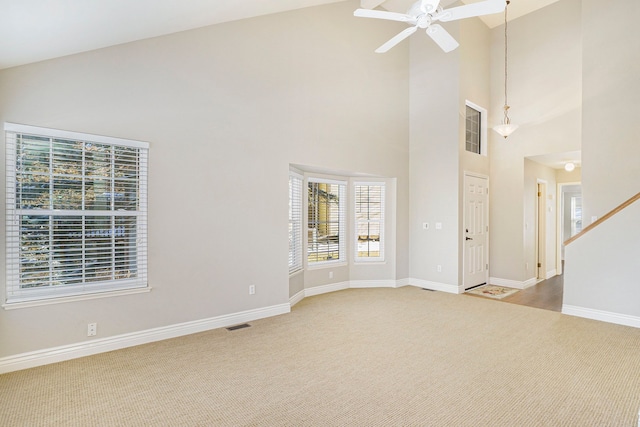 interior space featuring visible vents, a ceiling fan, carpet flooring, high vaulted ceiling, and baseboards