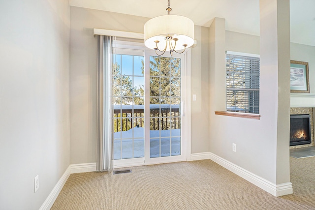 unfurnished dining area featuring carpet floors, a premium fireplace, and a wealth of natural light