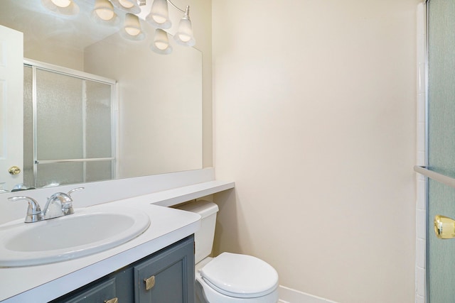 full bath with baseboards, a shower with shower door, vanity, and toilet