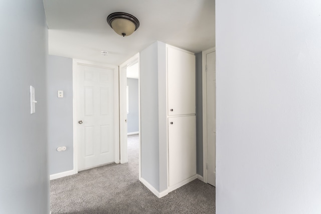 corridor with baseboards and carpet flooring